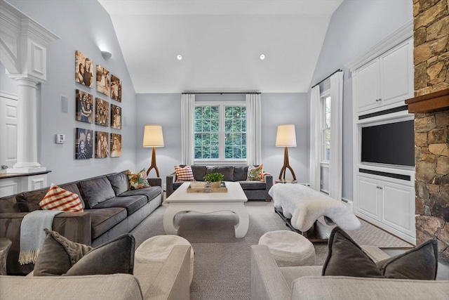 carpeted living room featuring decorative columns and lofted ceiling