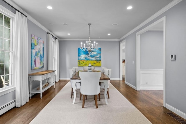 dining room featuring a chandelier, baseboard heating, crown molding, and dark wood-type flooring