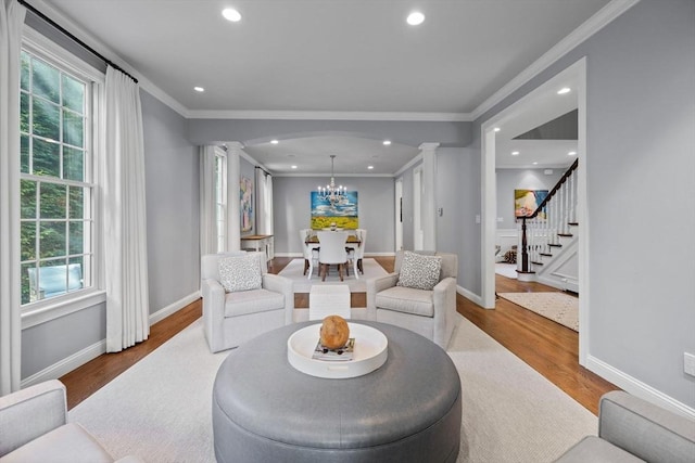 living room with ornate columns, a wealth of natural light, and hardwood / wood-style floors