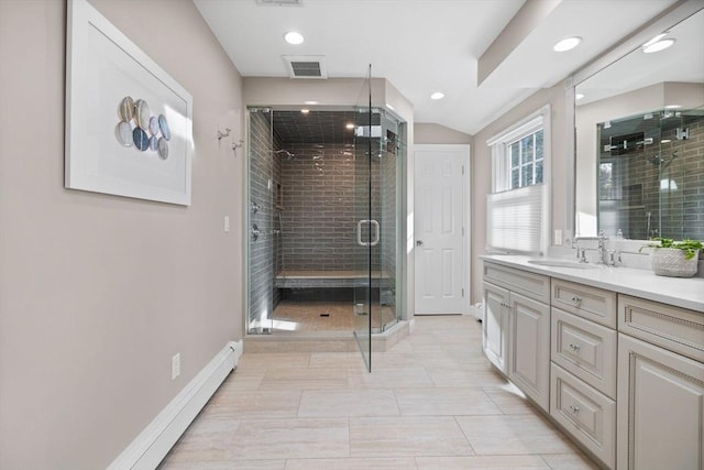 bathroom with a shower with shower door, baseboard heating, tile patterned floors, and vanity