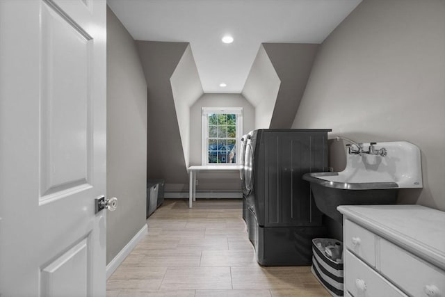 bathroom featuring sink, a baseboard radiator, and lofted ceiling