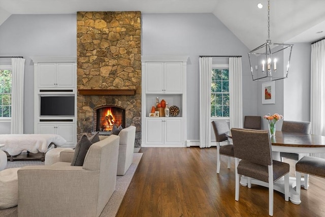 interior space featuring high vaulted ceiling, a healthy amount of sunlight, dark wood-type flooring, and a fireplace