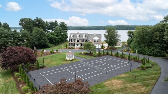 surrounding community featuring a yard, tennis court, and a water view