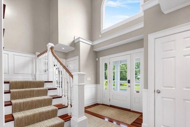 foyer entrance featuring hardwood / wood-style floors and a towering ceiling