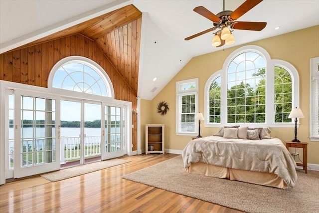 bedroom with multiple windows, a water view, access to exterior, and ceiling fan