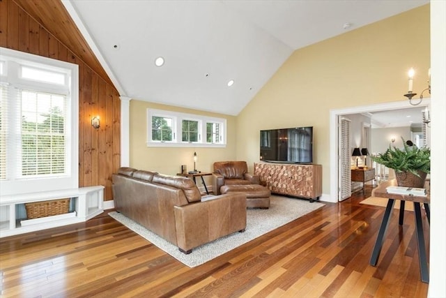 living room featuring high vaulted ceiling, wood-type flooring, decorative columns, and wood walls