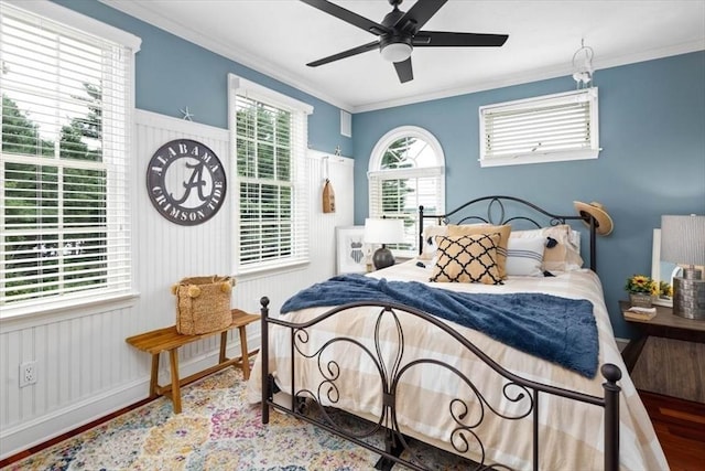 bedroom featuring hardwood / wood-style flooring, ornamental molding, and ceiling fan