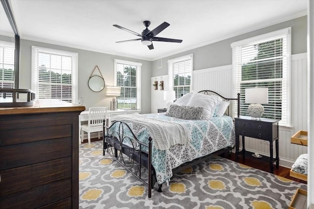 bedroom featuring ceiling fan, ornamental molding, hardwood / wood-style floors, and multiple windows