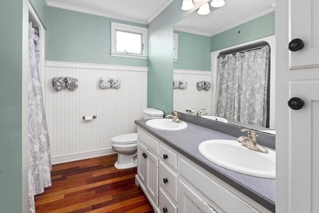 bathroom with crown molding, wood-type flooring, toilet, and vanity