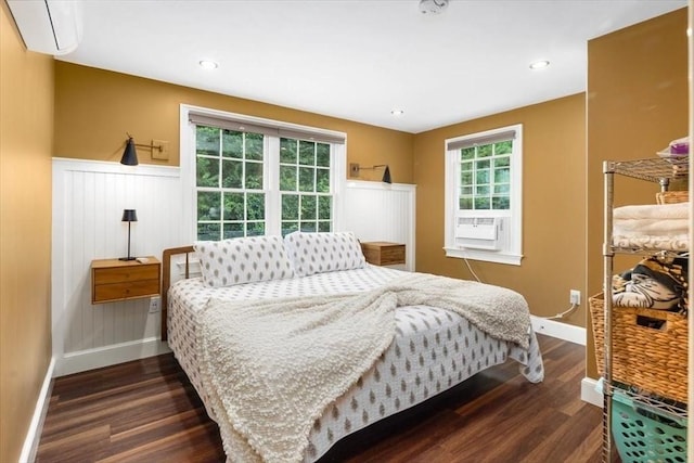 bedroom with cooling unit, a wall mounted air conditioner, and dark hardwood / wood-style floors