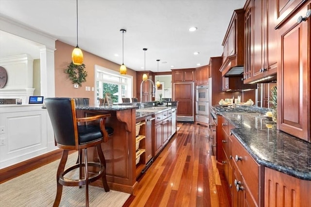 kitchen featuring a large island, a kitchen breakfast bar, and hanging light fixtures