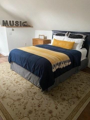 bedroom with lofted ceiling and hardwood / wood-style flooring