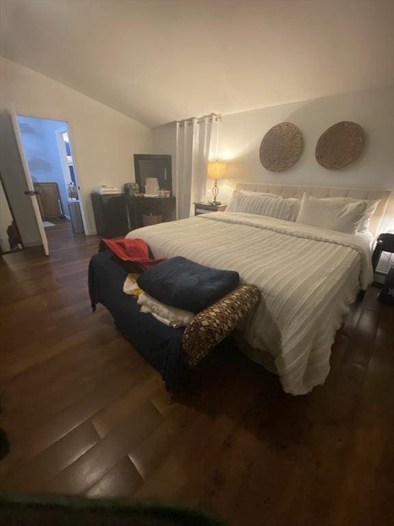 bedroom with vaulted ceiling and dark hardwood / wood-style floors