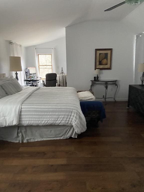 bedroom with ceiling fan, vaulted ceiling, and dark hardwood / wood-style floors