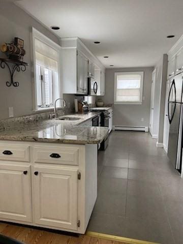 kitchen with sink, light stone counters, and white cabinetry