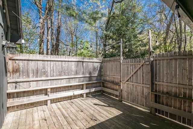 wooden deck featuring a gate and fence