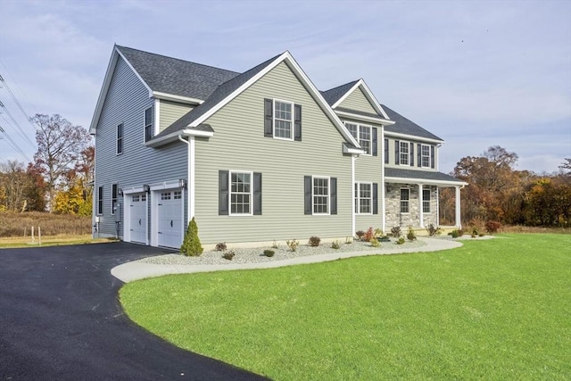 view of front of property with aphalt driveway, a front yard, roof with shingles, and an attached garage