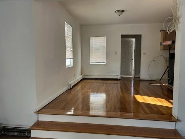 foyer featuring baseboard heating and wood finished floors