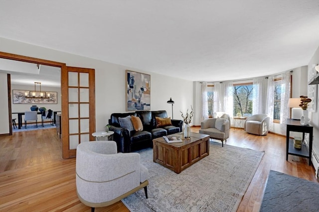 living room featuring a notable chandelier and light wood-type flooring