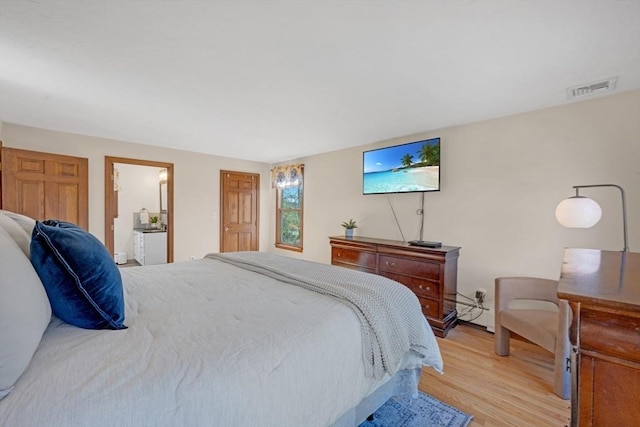 bedroom with visible vents, ensuite bath, and light wood-style floors