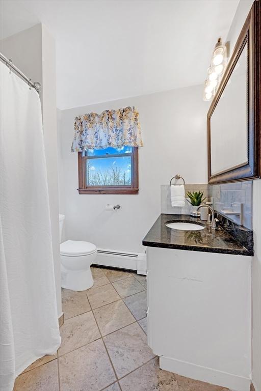 full bathroom featuring vanity, toilet, tile patterned flooring, and a baseboard radiator