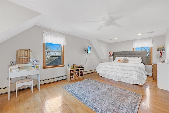 bedroom featuring visible vents, baseboard heating, a baseboard heating unit, and wood-type flooring