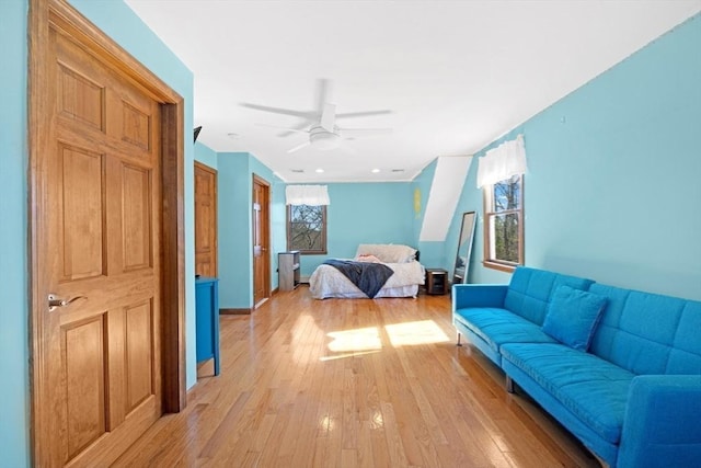 bedroom with baseboards, light wood finished floors, and ceiling fan