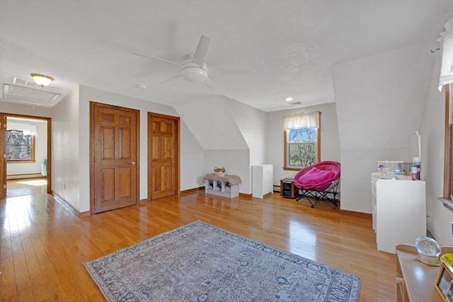 interior space featuring two closets, baseboards, light wood-type flooring, vaulted ceiling, and a ceiling fan