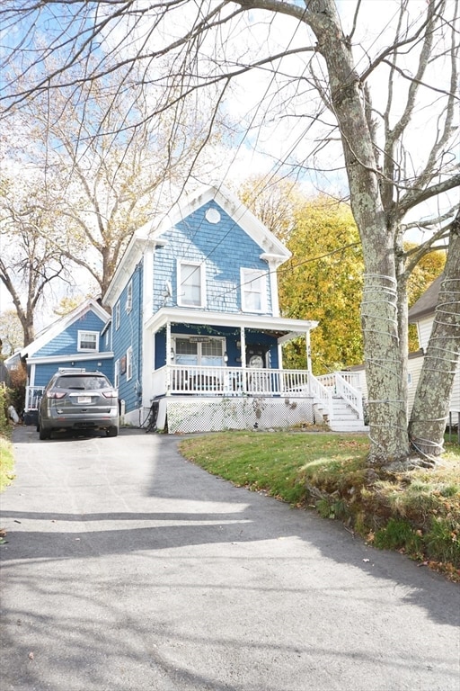 view of front facade featuring a front lawn, a garage, and covered porch