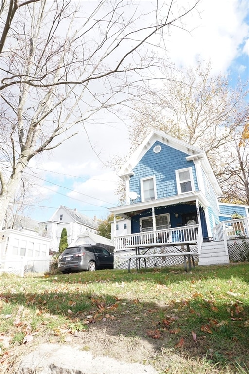 view of front of house with a front yard and covered porch