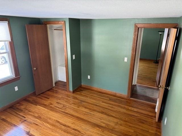 unfurnished bedroom with hardwood / wood-style floors and a closet