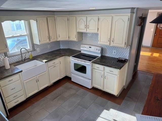 kitchen featuring sink, dark wood-type flooring, electric range, white cabinets, and decorative backsplash