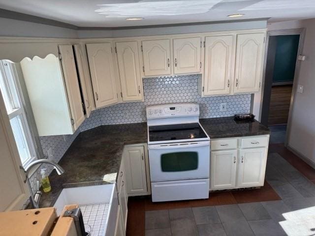 kitchen with white cabinetry, sink, decorative backsplash, and white range with electric cooktop