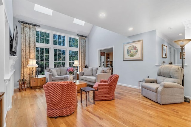 living room with light hardwood / wood-style floors and vaulted ceiling with skylight