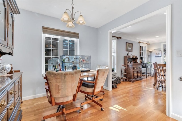 dining room with light hardwood / wood-style floors and an inviting chandelier