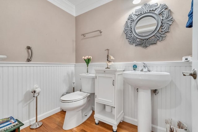 bathroom featuring toilet, crown molding, and wood-type flooring