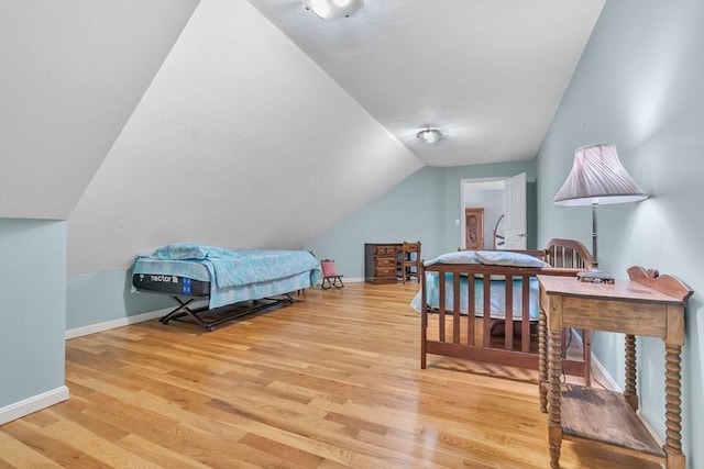 bedroom featuring vaulted ceiling and light hardwood / wood-style flooring