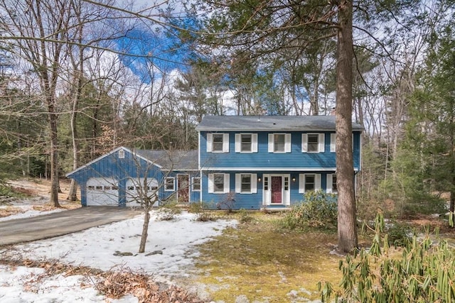 colonial home featuring a garage and aphalt driveway