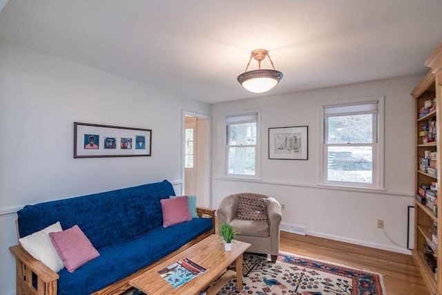 living area featuring wood finished floors, visible vents, and baseboards