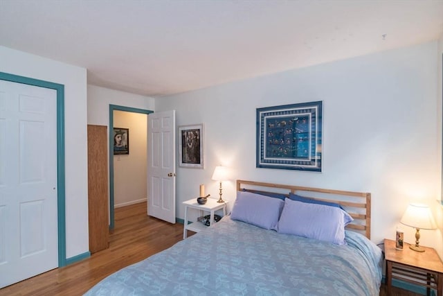 bedroom with baseboards and wood finished floors