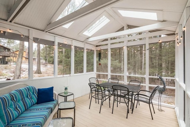 sunroom / solarium featuring a wealth of natural light and vaulted ceiling with skylight