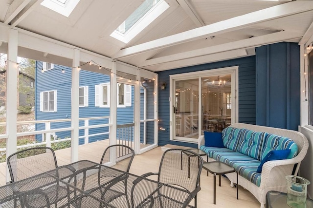 sunroom / solarium featuring vaulted ceiling with skylight