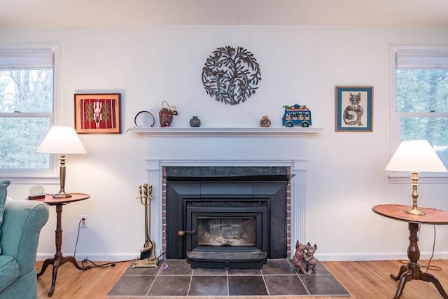 interior details featuring a fireplace, baseboards, and wood finished floors