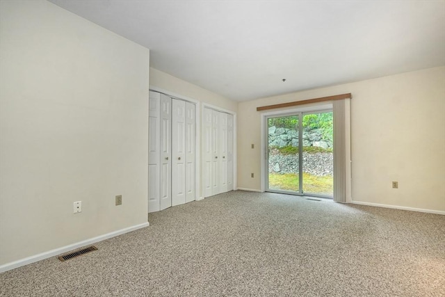 501 Lexington St Unit 105, Waltham, MA 02452 - unfurnished bedroom with access to outside, carpet floors, baseboards, and two closets