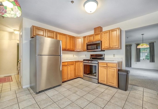 501 Lexington St Unit 105, Waltham, MA 02452 - kitchen featuring appliances with stainless steel finishes, light countertops, light tile patterned flooring, and baseboards