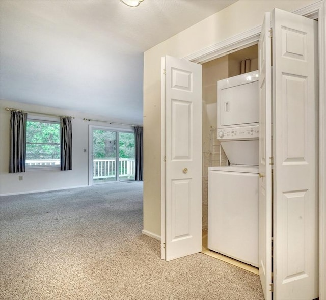 501 Lexington St Unit 105, Waltham, MA 02452 - laundry room with stacked washer / drying machine, light carpet, and baseboards