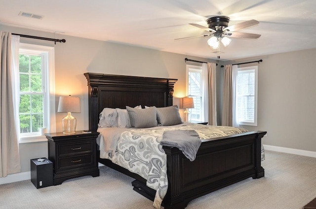 carpeted bedroom featuring multiple windows and ceiling fan