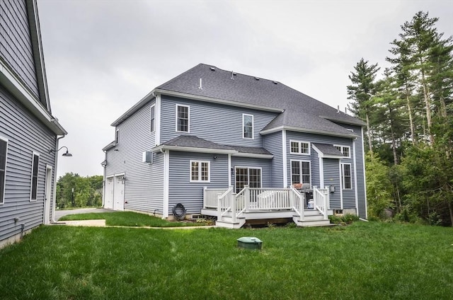 back of house with a yard, a garage, and a wooden deck