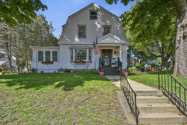 colonial inspired home featuring a front yard and a gambrel roof