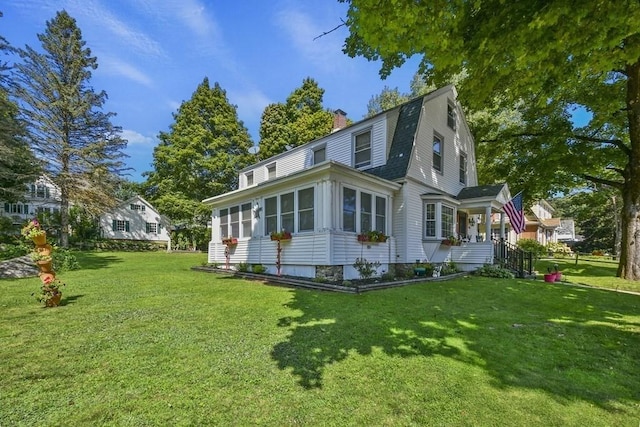 view of home's exterior featuring a yard, roof with shingles, a chimney, and a gambrel roof